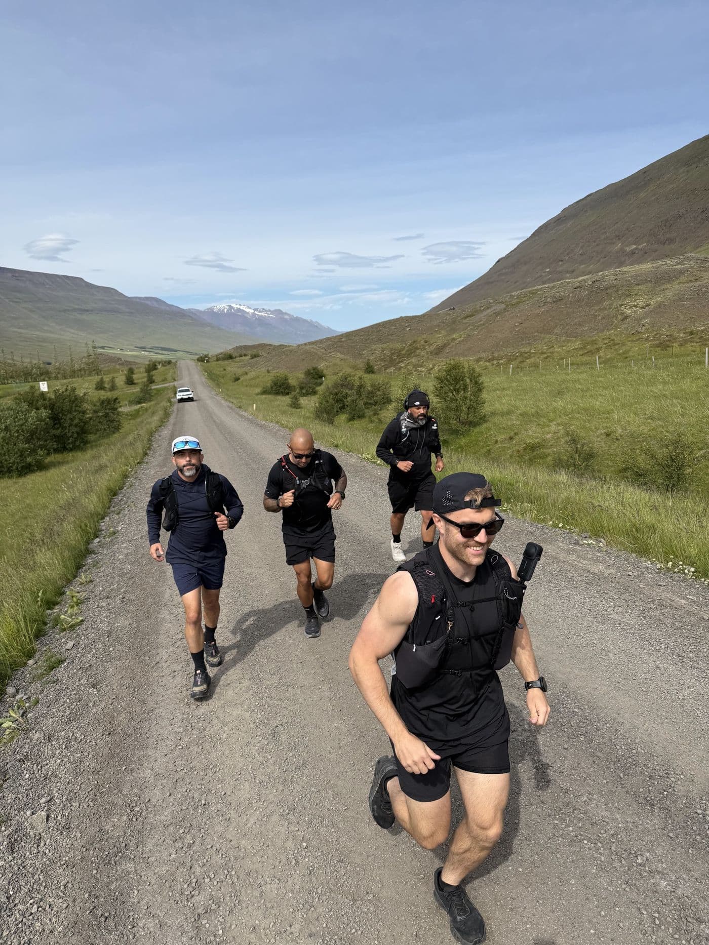 The crew running together down a gravel highland road