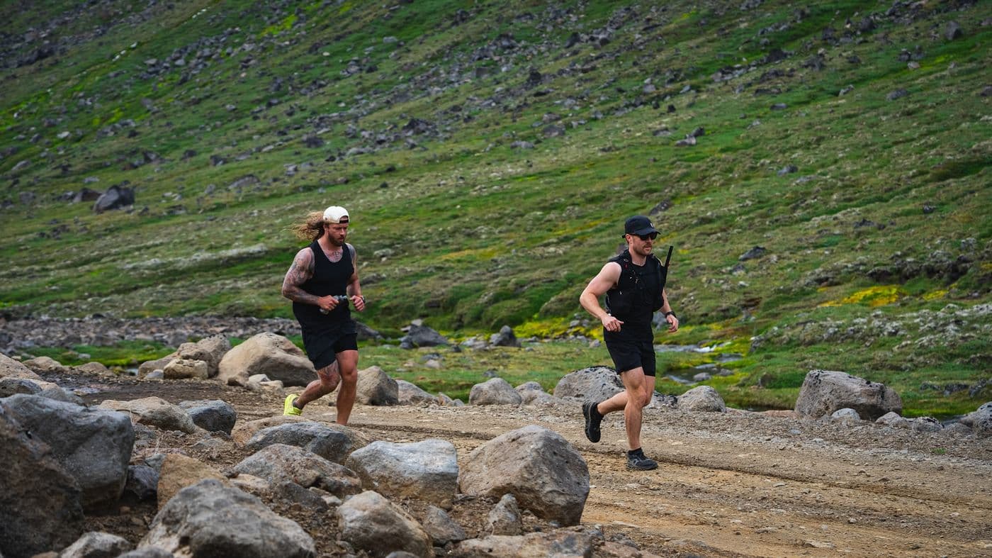 Runners scrambling over rocks